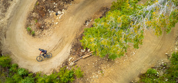Aerial view of a downhill mountain biker cornering on a trail at Trestle Bike Park at Winter Park Ski Resort in Winter Park, Colorado.